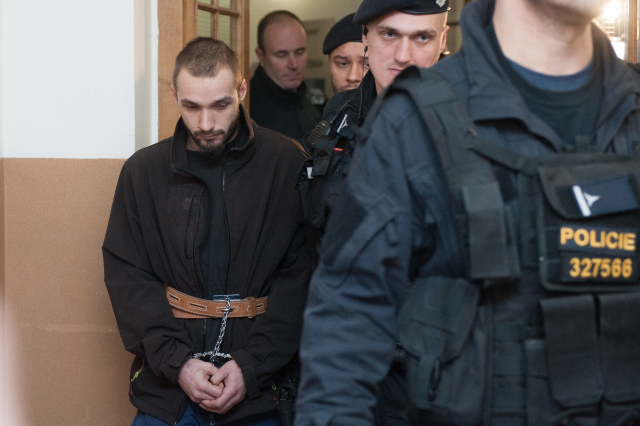 Jeden ze dvou mužů podezřelých z přepadení čerpací stanice v Nelahozevsi na Mělnicku, při kterém byla zavražděna čerpadlářka, odchází v doprovodu policisty 17. ledna 2019 ze soudní síně Okresního soudu v Mělníku, který rozhodoval o jeho vzetí do vazby.