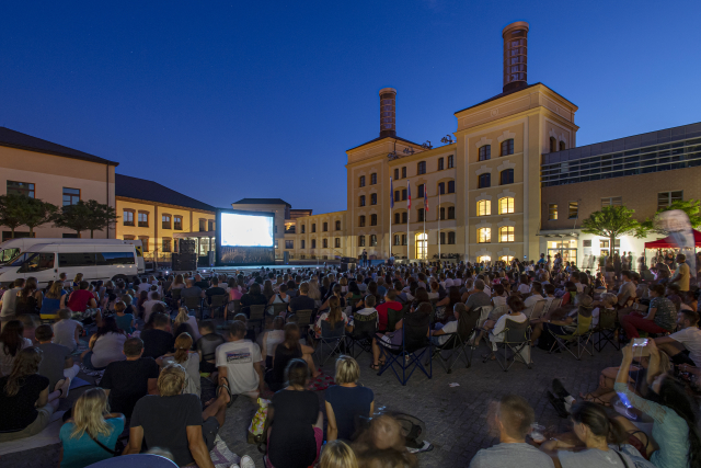 Lidé sledují film 25. července 2019 v letním kině na Pivovarském náměstí Hradci Králové. V areálu krajského úřadu biograf Etienne zdarma promítá přes léto každý čtvrtek. Projekt, který má podporu hejtmanství a několika sponzorů, přispívá k oživení této "úřednické" části stotisícového města.