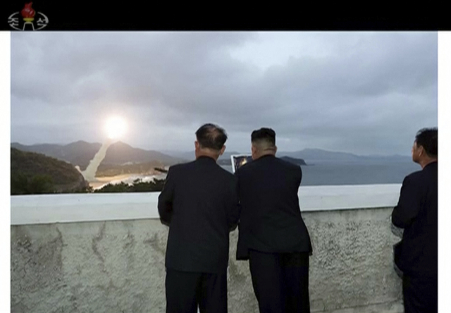 Kim Čong-un (vpravo) se přišel podívat na zkoušku nové rakety.