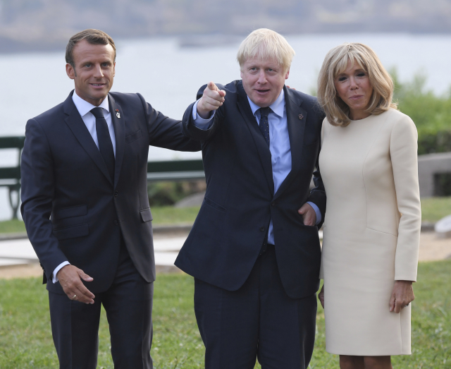 Boris Johnson (uprostřed) se po příjezdu do Francie zdraví s Emmanuelem Macronem a jeho manželkou.