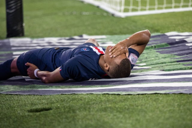 Kylian Mbappé na zemi poté, co ho píchlo ve stehně.