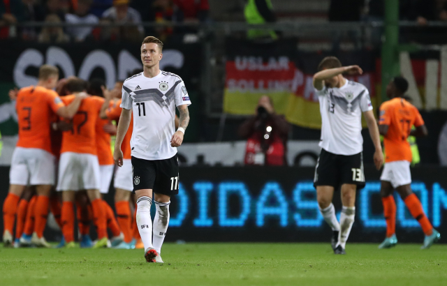 Smutný Marco Reus (v bílém). Vzadu se radují hráči Nizozemska.