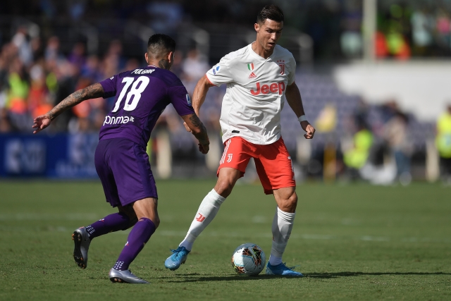 Cristiano Ronaldo (v bílém) se snaží zamotat hlavu Pulgarovi z Fiorentiny.
