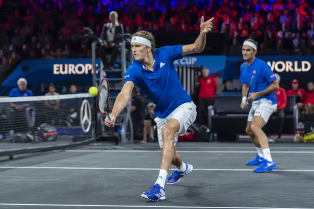Saša Zverev (uprostřed) zasahuje na síti vedle parťáka Rogera Federera.