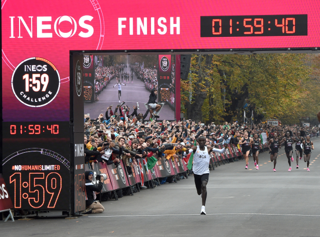 Eliud Kipchoge protíná celý šťastný cílovou pásku.
