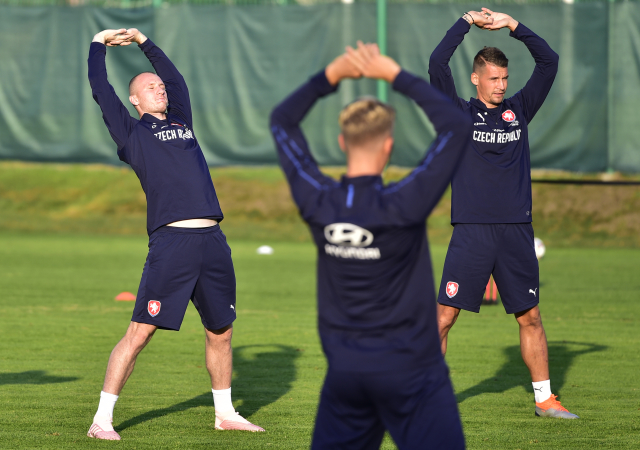 Útočník Michael Krmenčík (vlevo) a obránce Lukáš Hejda se protahují na tréninku české fotbalové reprezentace.