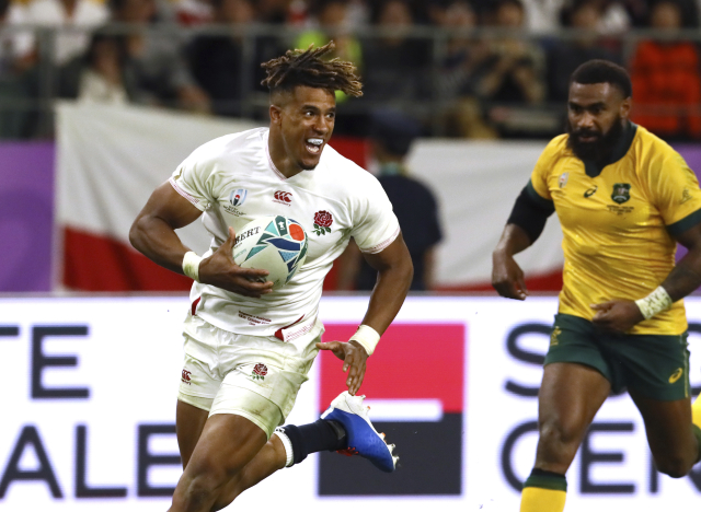 Anthony Watson z Anglie (vpravo) se snaží dostat skrz obranu Australanů.