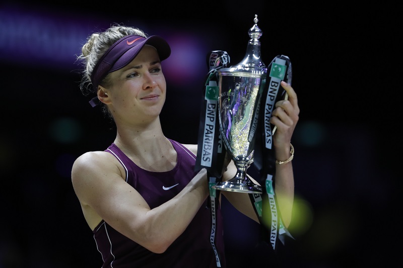 Elina Svitolinová zvedá nad hlavu trofej pro vítězku Turnaje mistryň roku 2018.