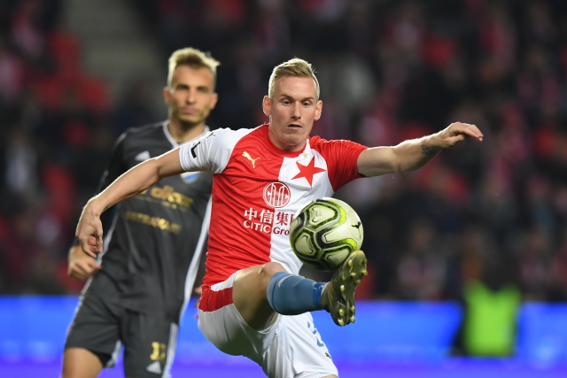 Petr Ševčík ze Slavie zpracovává míč, za ním Nemanja Kuzmanovič z Baníku.