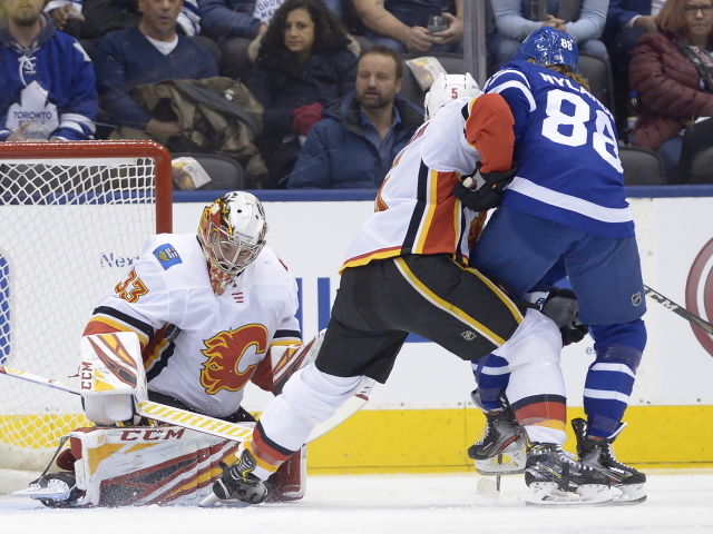Brankář Calgary Flames David Rittich (33), Mark Giordano (5) a hokejista Toronta William Nylander (88).