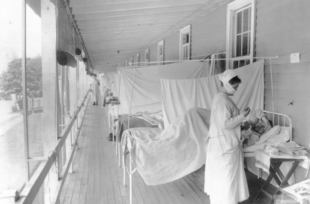 Infekční oddělení s pacienty, kteří onemocněli španělskou chřipkou. Snímek byl pořízen v roce 1918 v USA.