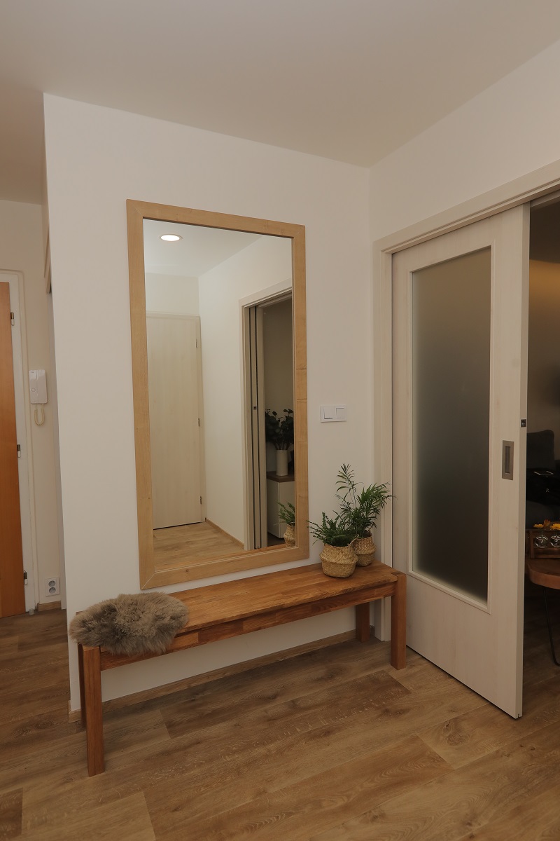 Chodba je jednoduchá a vévodí jí velké zrcadlo.