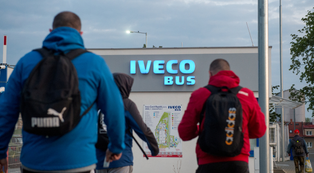 Zaměstnanci vcházející do firmy Iveco po více než měsíční odstávce.