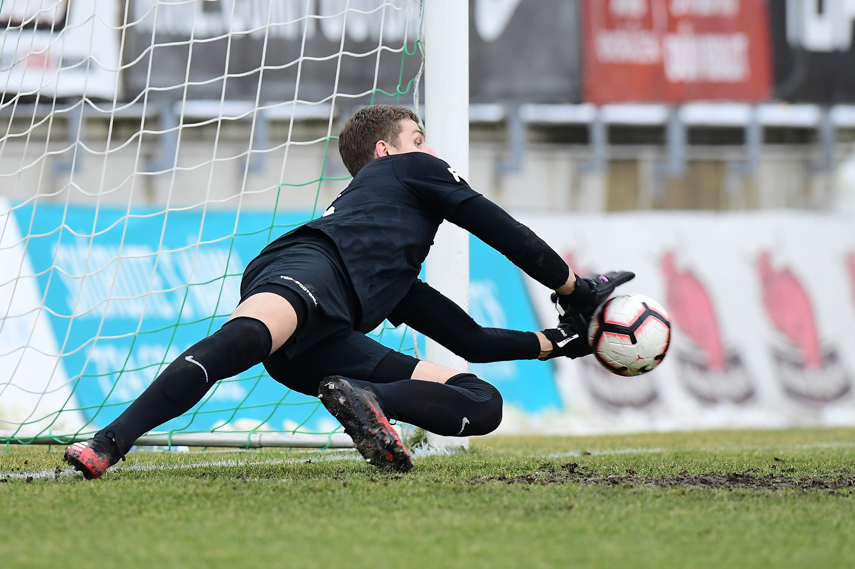 Brankář Ondřej Kočí chytá penaltu.