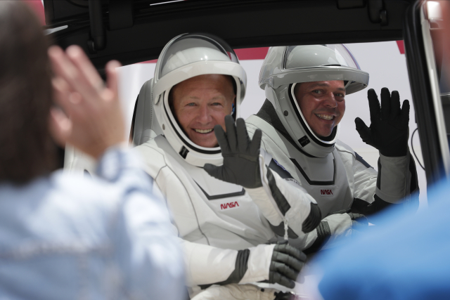 Astronauti Douglas Hurley (vlevo) a Robert Behnken před nástupem na palubu lodi 27. května, než se start rakety odvolal. 