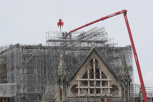 Dělníci odstraňují z katedrály Notre-Dame lešení.