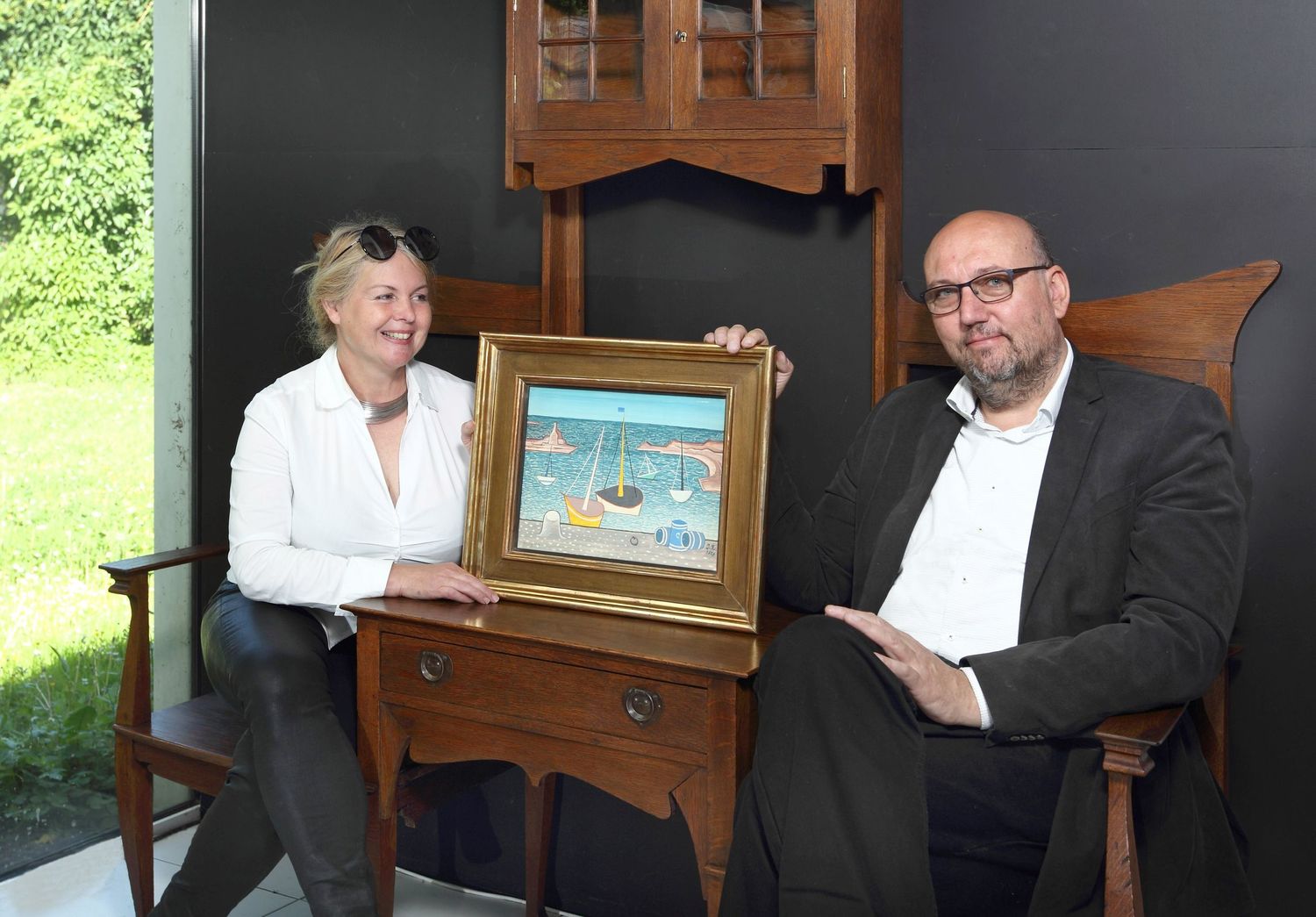 Marie a Tomáš Hejtmánkovi, majitelé aukční síně Arthouse Hejtmánek, s obrazem Loďky v přístavu Jana Zrzavého.