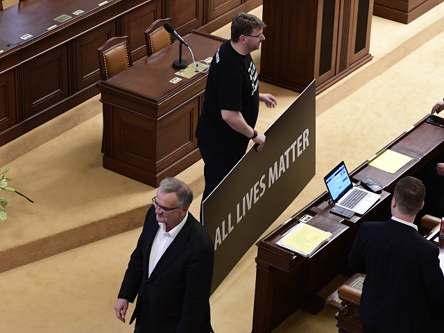 Poslanec Lubomír Volný (držící transparent).