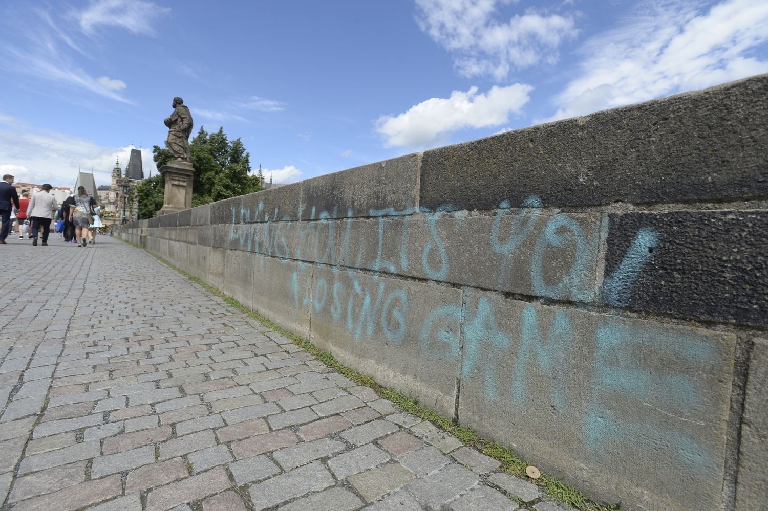 Neznámý vandal 9. července 2021 posprejoval část Karlova mostu v Praze. Modré nápisy v angličtině jsou na zídce na pravé straně mostu směrem k Pražskému hradu.