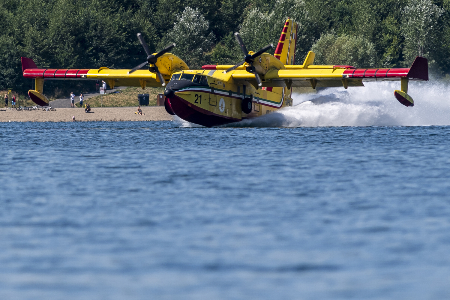 Na letiště Vodochody 5. srpna 2022 kolem poledne dorazí z Itálie dvě letadla Canadair (na snímku z 28. července 2022 jeden ze strojů nabírá vodu na jezeře Milada u Ústí nad Labem při první akci v ČR), aby opět pomohla s hašením požáru v Českém Švýcarsku.