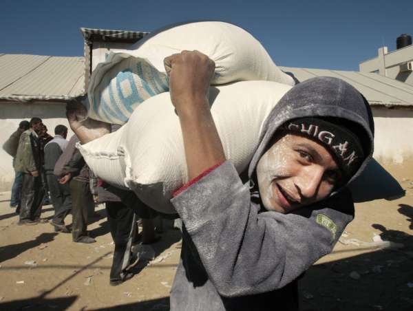 Palestinec si nese potravinovou pomoc ze škladišť UNRWA. Palestinec si nese potravinovou pomoc ze škladišť UNRWA.