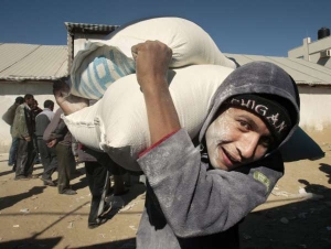 Palestinec si nese potravinovou pomoc ze &scaron;kladi&scaron;ť UNRWA.