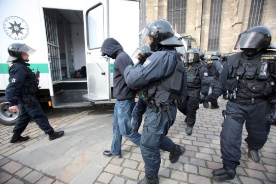 Policisté odvádějí zakuklence.