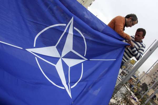 Albánci vyvěšují vlajku NATO v hlavním městě Tiraně.