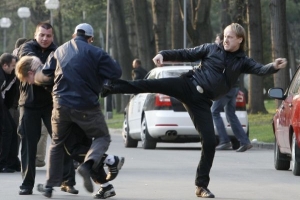 Policisté v civilu kopou zadrženého demonstranta.