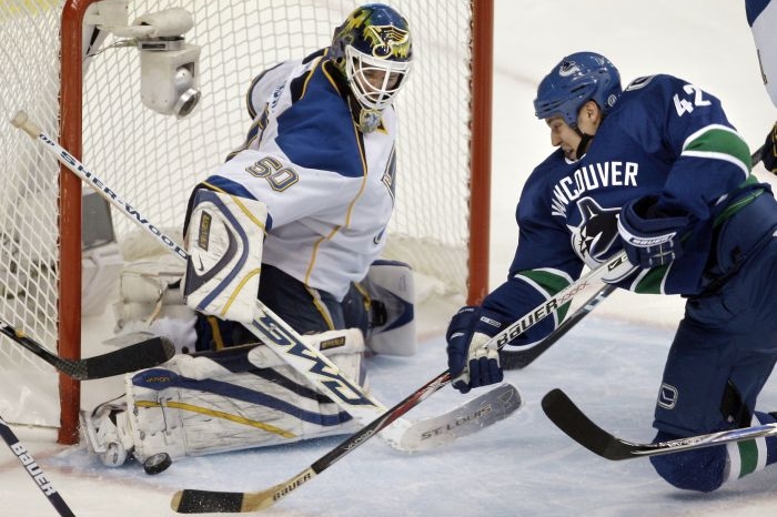 Kyle Wellwood z Vancouveru se snaží dostat puk do branyk St. Louis. Kyle Wellwood z Vancouveru se snaží dostat puk do branyk St. Louis.