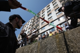 Policiejní pásky. Policisté musí udržet znepřátelené skupiny od sebe.