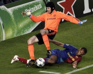 Petr Čech řpi souboji s hvězdou Barcelony Thierrym Henrym.