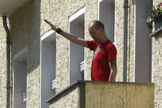 Sympatizant NPD v Berlíně zdraví své soukmenovce na ulici.