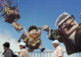 Lidé míjejí obří reklamu na zahajovací film Vzhůru do oblak.