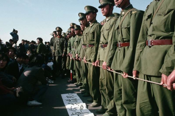 Policie zastavuje protestující studenty v Pekingu roku 1989.