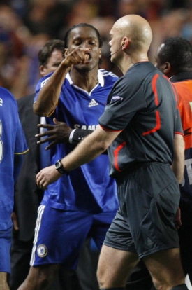 Didier Drogba a rozhodčí Henning Övrebö.