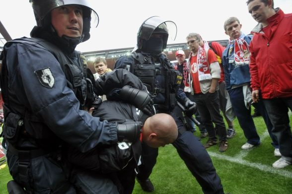 Policie odvádí fanouška z plochy stadionu v Edenu.