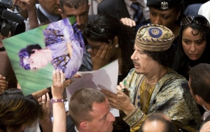 Kaddáfí rozdává autogramy Italkám.