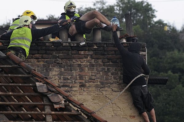Hasiči sundávají ze střechy vily poslední squattery.