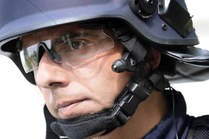 Policista s minikamerou u levého ucha.