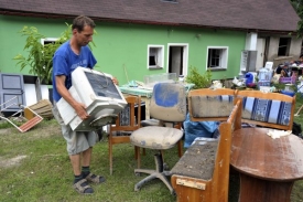 Muž uklízí následky bleskové povodně v Dolních Habarticích.