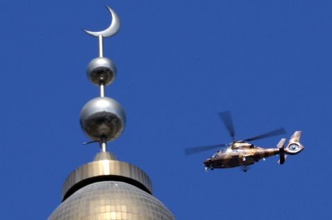 Policejní helikoptéra krouží nad mešitou v Urumqi. 