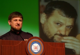 Ramzan Kadyrov s projekcí svého otce v pozadí.