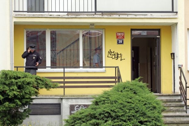 Policista u vchodu do domu, kde se drama odehrálo. Policista u vchodu do domu, kde se drama odehrálo.