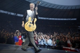 Basista Adam Clayton se předvádí před fanoušky.