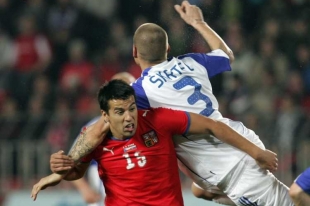 Slovenský zadák Martin Šktel v souboji s Milanem Barošem.