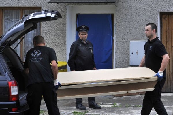 Pracovníci pohřební služby odváží jednu z rakví.