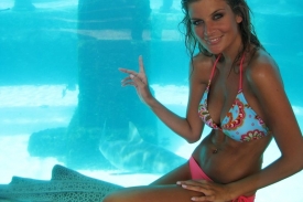 Iveta Lutovská u obřího akvária se žraloky.