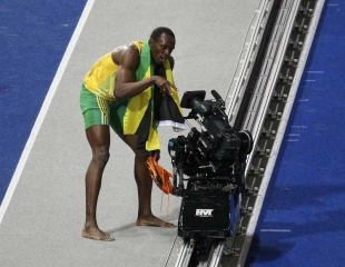Usain Bolt koketuje s televizn&iacute; kamerou.