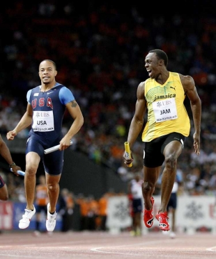 Usain Bolt (vpravo) se zub&iacute; na Američana Spearmona.